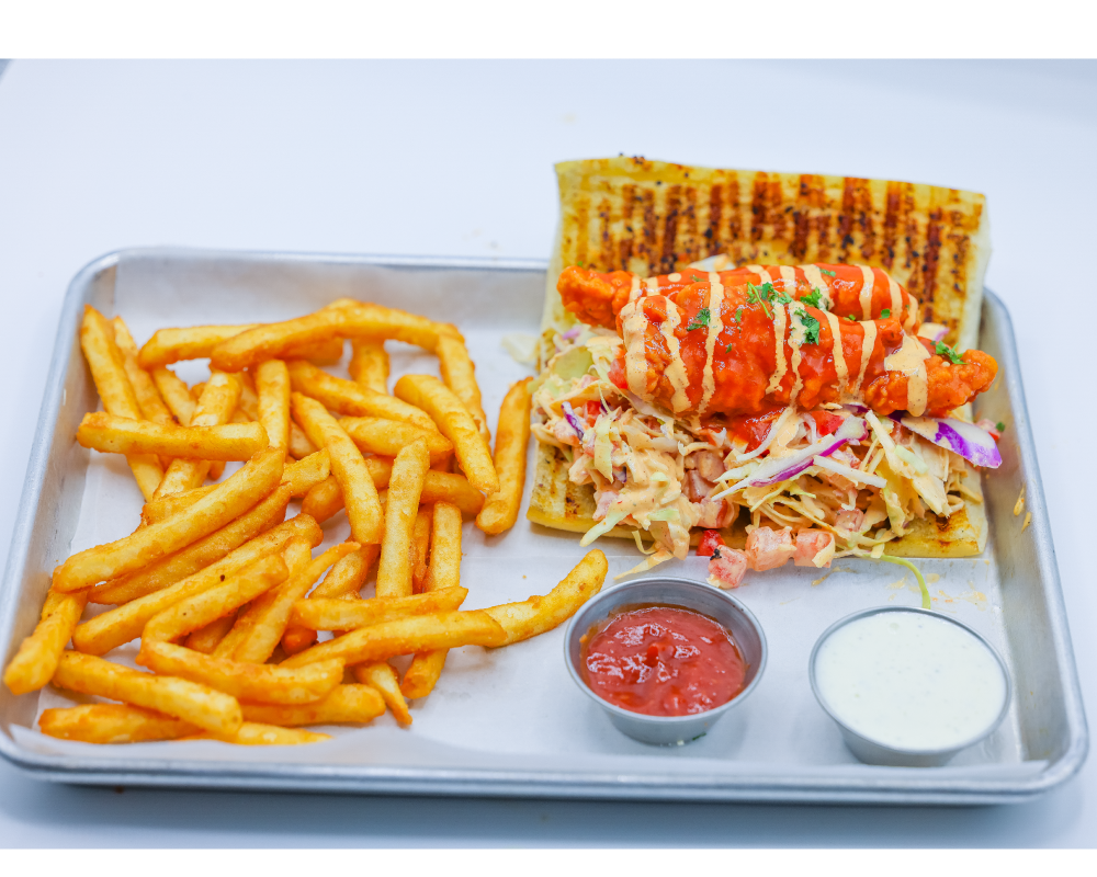 Bufaalo chicken sandwich served with french fries on a silver platter
