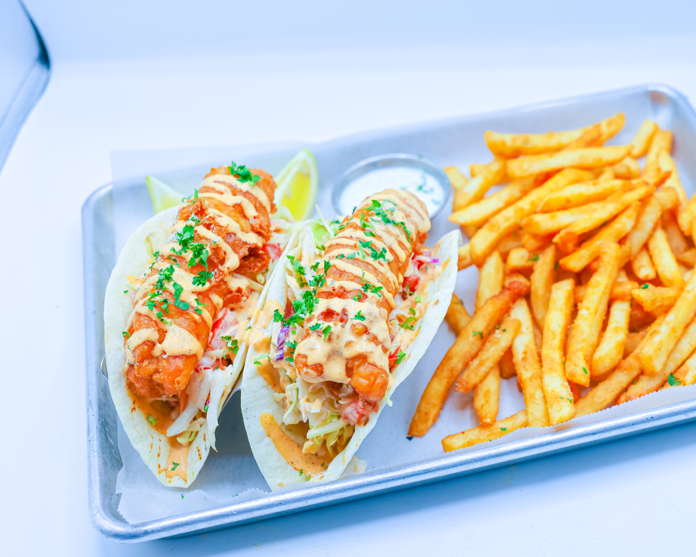 New fish tacos with fries topped with taco sauce and cilantro